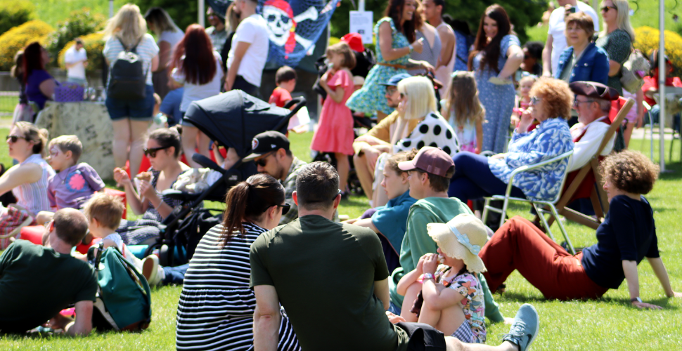 Families sit on the lawn at the Royal William Yard